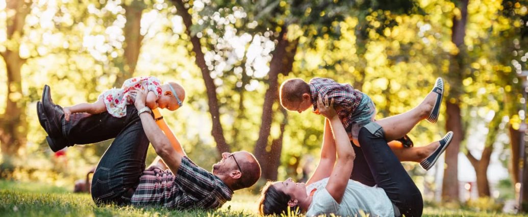 A joyful family enjoying playtime in a sunny park, capturing moments of laughter and happiness.