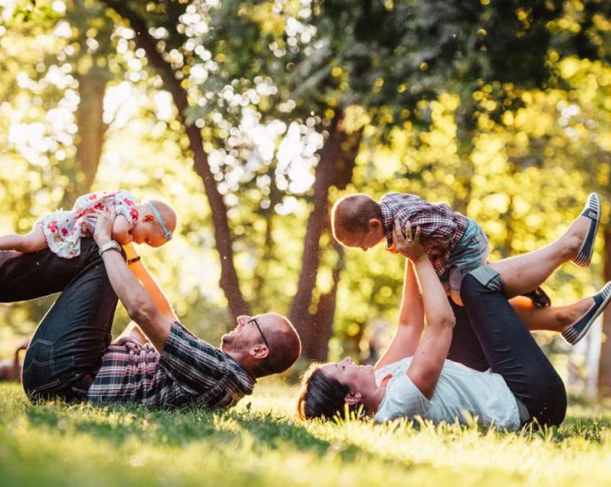 A joyful family enjoying playtime in a sunny park, capturing moments of laughter and happiness.